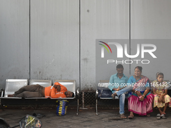 A food delivery person sleeps inside a bus stand in Kolkata, India, on October 10, 2024. (