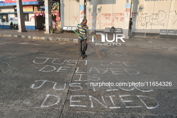 A person cleans a bus stand in the early morning in Kolkata, India, on October 10, 2024. 