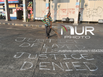 A person cleans a bus stand in the early morning in Kolkata, India, on October 10, 2024. (