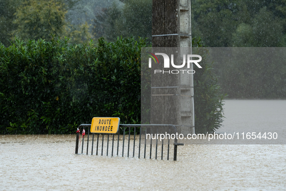 A road sign reads ''flooded road'' on a flooded street in Pommeuse, Seine-et-Marne department, east of Paris, on October 10, 2024, as the he...