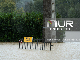 A road sign reads ''flooded road'' on a flooded street in Pommeuse, Seine-et-Marne department, east of Paris, on October 10, 2024, as the he...