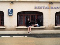 Two young people sit next to a flooded street in Coulommiers, Seine-et-Marne department, east of Paris, on October 10, 2024, as the heavy ra...