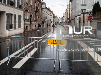 A road sign that reads ''flooded road'' is displayed on a flooded street in Coulommiers, Seine-et-Marne department, east of Paris, on Octobe...