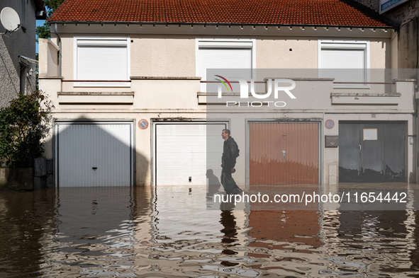 A man walks down a flooded street in Coulommiers, Seine-et-Marne department, east of Paris, on October 10, 2024, as the heavy rains associat...