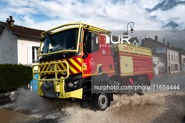 A fire truck drives over a flooded street in Coulommiers, Seine-et-Marne department, east of Paris, on October 10, 2024, as the heavy rains...