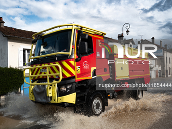 A fire truck drives over a flooded street in Coulommiers, Seine-et-Marne department, east of Paris, on October 10, 2024, as the heavy rains...