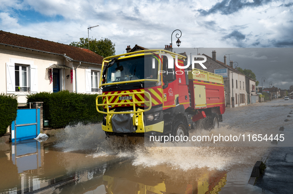 A fire truck drives over a flooded street in Coulommiers, Seine-et-Marne department, east of Paris, on October 10, 2024, as the heavy rains...