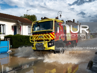 A fire truck drives over a flooded street in Coulommiers, Seine-et-Marne department, east of Paris, on October 10, 2024, as the heavy rains...