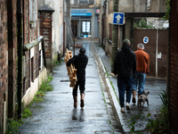 Three men bring tools to clean a flooded house in Coulommiers, Seine-et-Marne department, east of Paris, on October 10, 2024, as the heavy r...