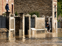 A man pulls water off his house on a flooded street in Coulommiers, Seine-et-Marne department, east of Paris, on October 10, 2024, as the he...