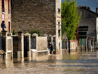 A man pulls water off his house on a flooded street in Coulommiers, Seine-et-Marne department, east of Paris, on October 10, 2024, as the he...