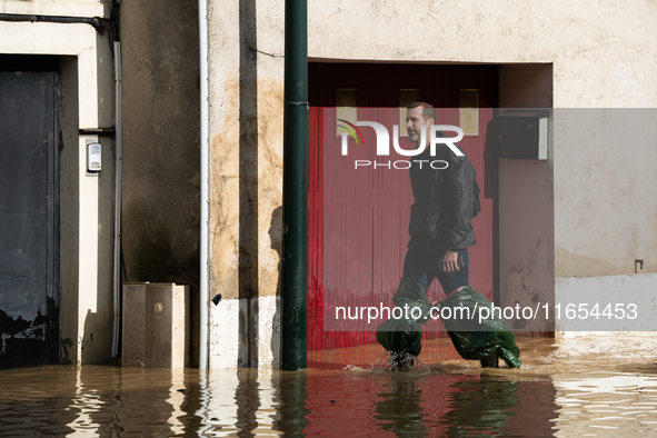 A man walks down a flooded street in Coulommiers, Seine-et-Marne department, east of Paris, on October 10, 2024, as the heavy rains associat...