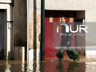 A man walks down a flooded street in Coulommiers, Seine-et-Marne department, east of Paris, on October 10, 2024, as the heavy rains associat...