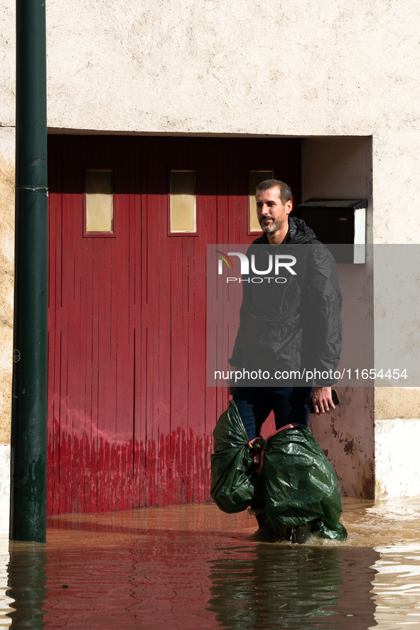 A man walks down a flooded street in Coulommiers, Seine-et-Marne department, east of Paris, on October 10, 2024, as the heavy rains associat...