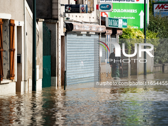 A man walks down a flooded street in Coulommiers, Seine-et-Marne department, east of Paris, on October 10, 2024, as the heavy rains associat...