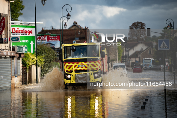 A fire truck drives over a flooded street in Coulommiers, Seine-et-Marne department, east of Paris, on October 10, 2024, as the heavy rains...