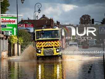 A fire truck drives over a flooded street in Coulommiers, Seine-et-Marne department, east of Paris, on October 10, 2024, as the heavy rains...