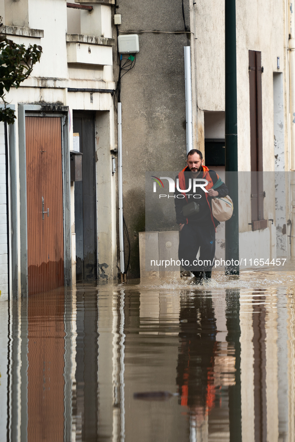 A man walks down a flooded street in Coulommiers, Seine-et-Marne department, east of Paris, on October 10, 2024, as the heavy rains associat...