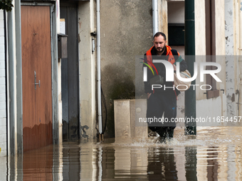 A man walks down a flooded street in Coulommiers, Seine-et-Marne department, east of Paris, on October 10, 2024, as the heavy rains associat...