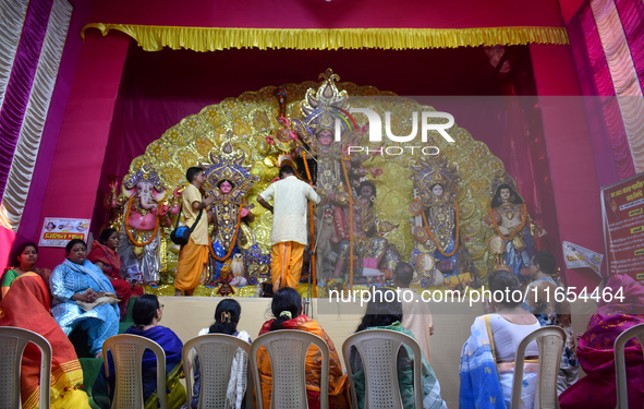 Devotees worship an idol of the Hindu goddess Durga inside a temporary platform called a pandal during the Hindu religious festival Durga Pu...