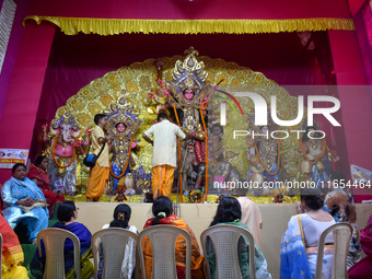 Devotees worship an idol of the Hindu goddess Durga inside a temporary platform called a pandal during the Hindu religious festival Durga Pu...