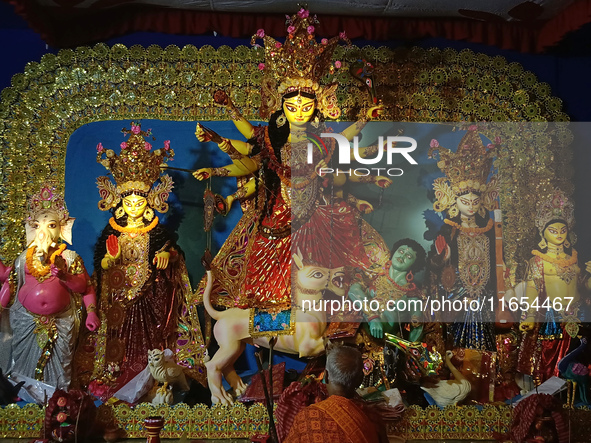 A priest worships an idol of the Hindu goddess Durga inside a temporary platform called a pandal during the Hindu religious festival Durga P...