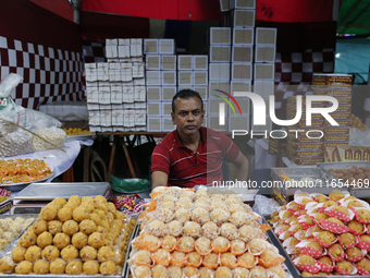 A vendor sells sweets outside a temple during the Durga Puja festival in Dhaka, Bangladesh, on October 10, 2024. (