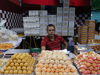 A vendor sells sweets outside a temple during the Durga Puja festival in Dhaka, Bangladesh, on October 10, 2024. (