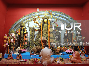 Devotees worship an idol of the Hindu goddess Durga inside a temporary platform called a pandal during the Hindu religious festival Durga Pu...