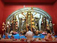 Devotees worship an idol of the Hindu goddess Durga inside a temporary platform called a pandal during the Hindu religious festival Durga Pu...