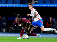 Riccardo Calafiori of Italy and Jeremy Doku of Belgium compete for the ball during the UEFA Nations League 2024/25 League A Group A2 match b...