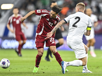 Abdelrahman Fahmi Moustafa (L) of Qatar battles for the ball with Kichin Valerii (R) of Kyrgyzstan during the FIFA World Cup 2026 AFC Asian...