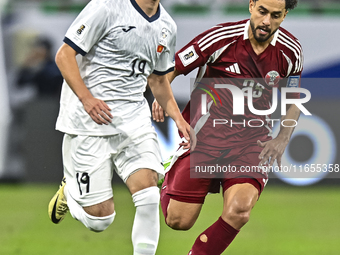 Abdelrahman Fahmi Moustafa of Qatar battles for the ball with Ermek Kenzhebaev of Kyrgyzstan during the FIFA World Cup 2026 AFC Asian Qualif...