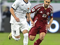 Abdelrahman Fahmi Moustafa of Qatar battles for the ball with Ermek Kenzhebaev of Kyrgyzstan during the FIFA World Cup 2026 AFC Asian Qualif...