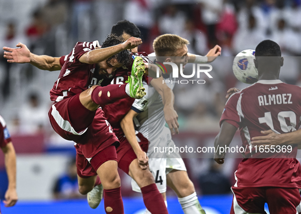 Almoez Ali (R) of Qatar battles for the ball with Aleksandr Mishchenko (C) of Kyrgyzstan during the FIFA World Cup 2026 AFC Asian Qualifiers...