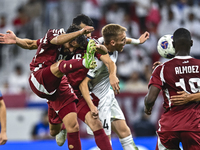 Almoez Ali (R) of Qatar battles for the ball with Aleksandr Mishchenko (C) of Kyrgyzstan during the FIFA World Cup 2026 AFC Asian Qualifiers...