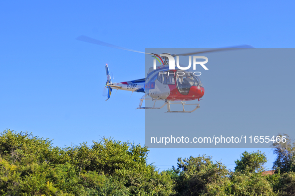 A Heli General Aviation AC311 helicopter performs a sightseeing flight in Yantai, China, on October 1, 2023. The Civil Aviation Administrati...