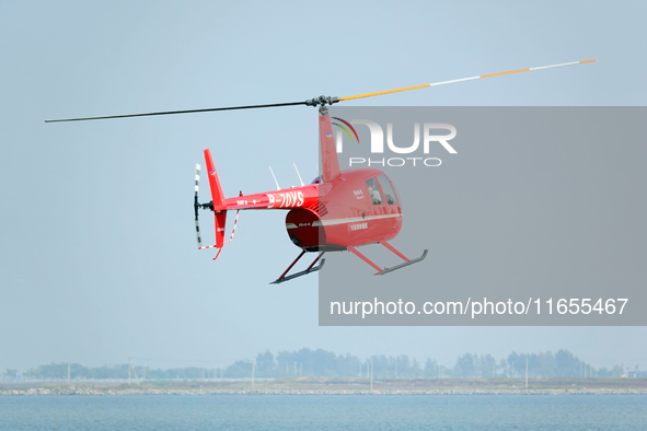 A Tianjin Jinjintong R44 helicopter performs a sightseeing flight in Binhai New Area, Tianjin, China, on October 4, 2023. The Civil Aviation...