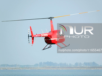 A Tianjin Jinjintong R44 helicopter performs a sightseeing flight in Binhai New Area, Tianjin, China, on October 4, 2023. The Civil Aviation...