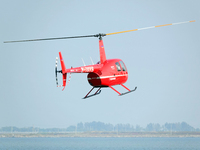 A Tianjin Jinjintong R44 helicopter performs a sightseeing flight in Binhai New Area, Tianjin, China, on October 4, 2023. The Civil Aviation...