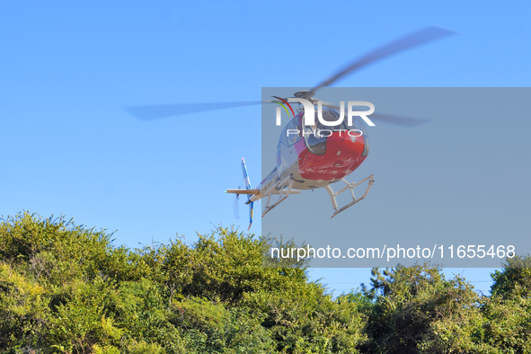 A Heli General Aviation AC311 helicopter performs a sightseeing flight in Yantai, China, on October 1, 2023. The Civil Aviation Administrati...