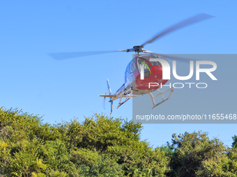 A Heli General Aviation AC311 helicopter performs a sightseeing flight in Yantai, China, on October 1, 2023. The Civil Aviation Administrati...