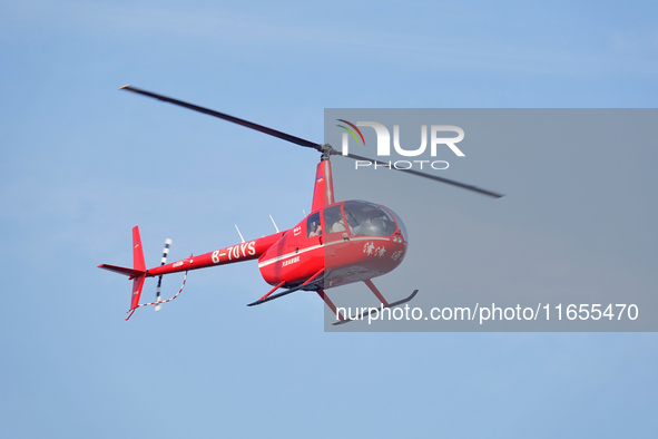 A Tianjin Jinjintong R44 helicopter performs a sightseeing flight in Binhai New Area, Tianjin, China, on October 4, 2023. The Civil Aviation...