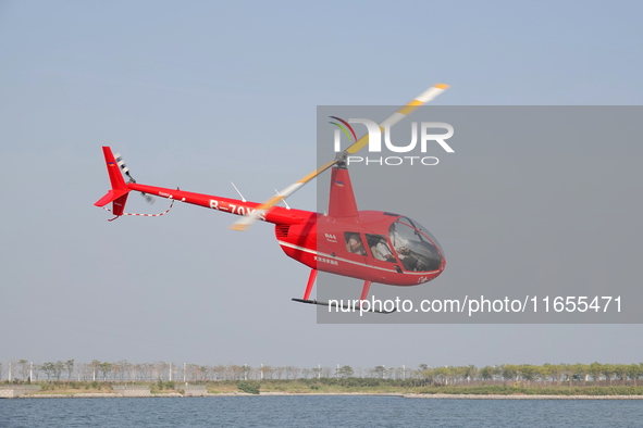 A Tianjin Jinjintong R44 helicopter performs a sightseeing flight in Binhai New Area, Tianjin, China, on October 4, 2023. The Civil Aviation...