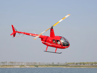 A Tianjin Jinjintong R44 helicopter performs a sightseeing flight in Binhai New Area, Tianjin, China, on October 4, 2023. The Civil Aviation...