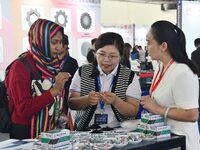 An exhibitor introduces fastener product information to foreign merchants at the 2024 International Procurement Conference in Handan, China,...