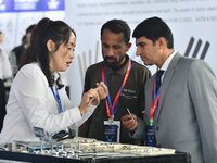 An exhibitor introduces fastener product information to foreign merchants at the 2024 International Procurement Conference in Handan, China,...