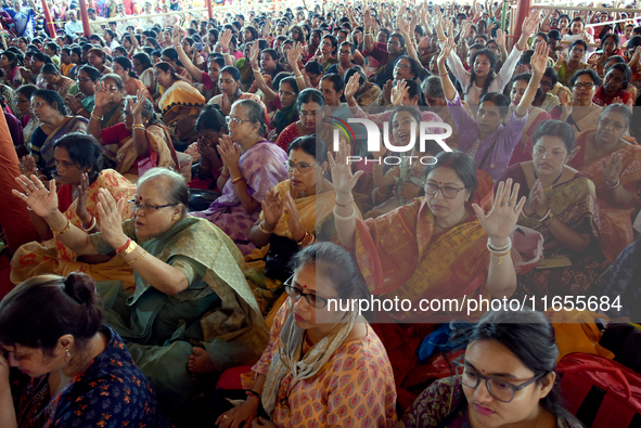 Devotees attend to watch a priest of the Ramakrishna Mission perform arati for a living goddess Kumari in front of a clay image of the Hindu...