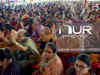 Devotees attend to watch a priest of the Ramakrishna Mission perform arati for a living goddess Kumari in front of a clay image of the Hindu...