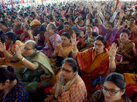 Devotees attend to watch a priest of the Ramakrishna Mission perform arati for a living goddess Kumari in front of a clay image of the Hindu...